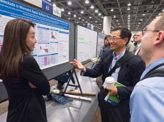 Dung T. Le, MD, (left) presents Abstract 6 in a Poster Session.
