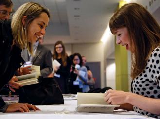 Dr. Lucy Kalanithi (right) signs a copy of "When Breath Becomes Air" for Andrea M. Ferrian, MD, during the ASCO Book Club session at the 2016 ASCO Annual Meeting