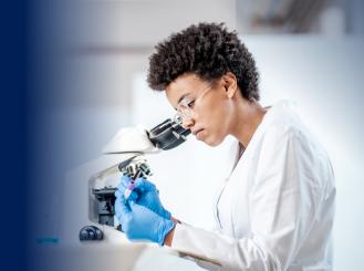 Doctor looking in microscope stock image