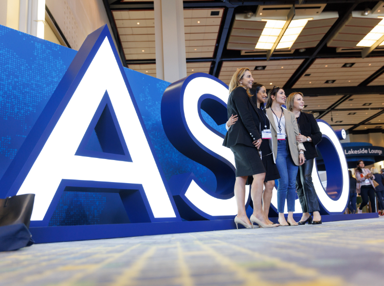 Group posed in front of ASCO sign