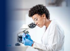 Doctor looking in microscope stock image